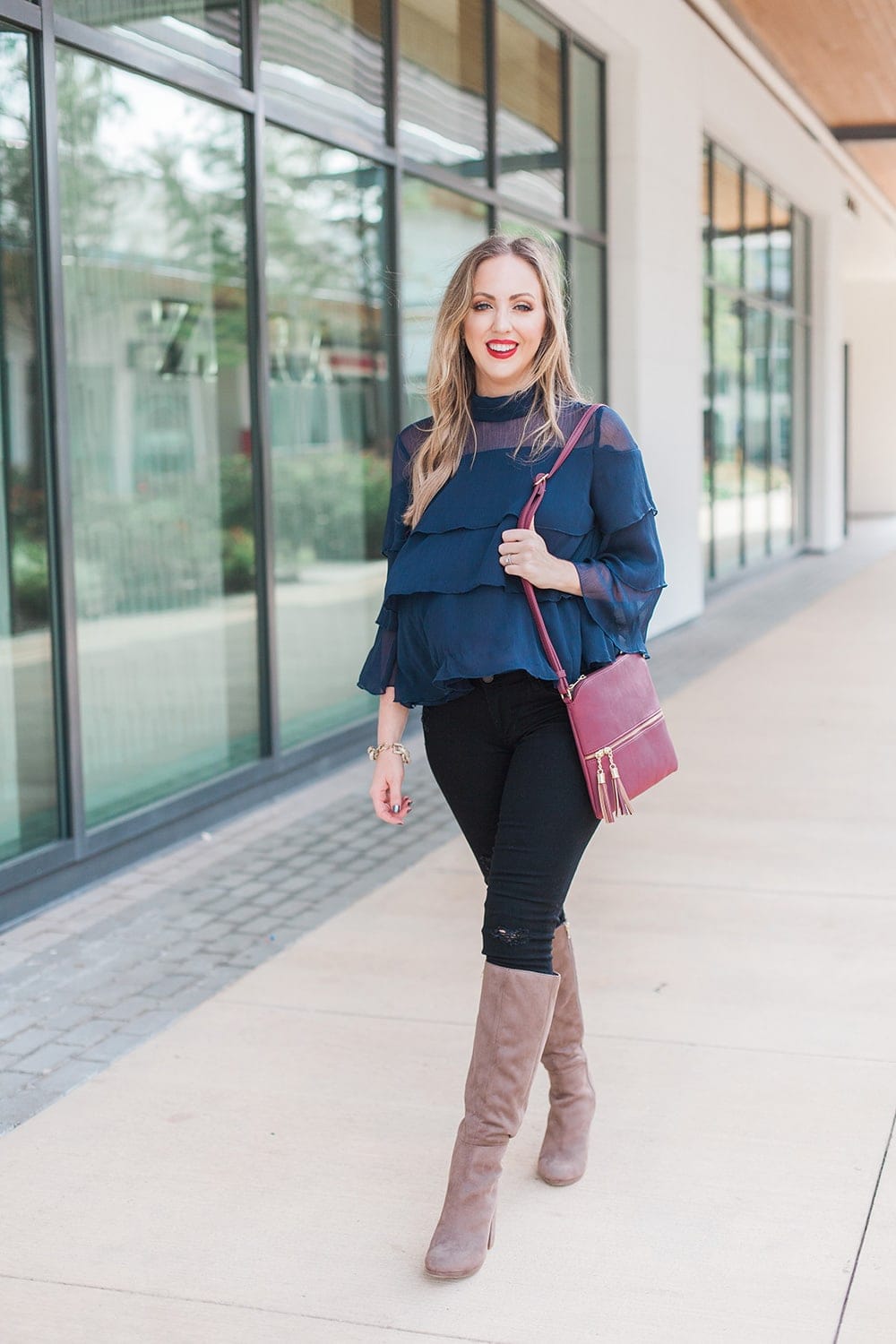 gorgeous fall or holiday outfit idea - ruffle blouse with distressed denim and tall boots