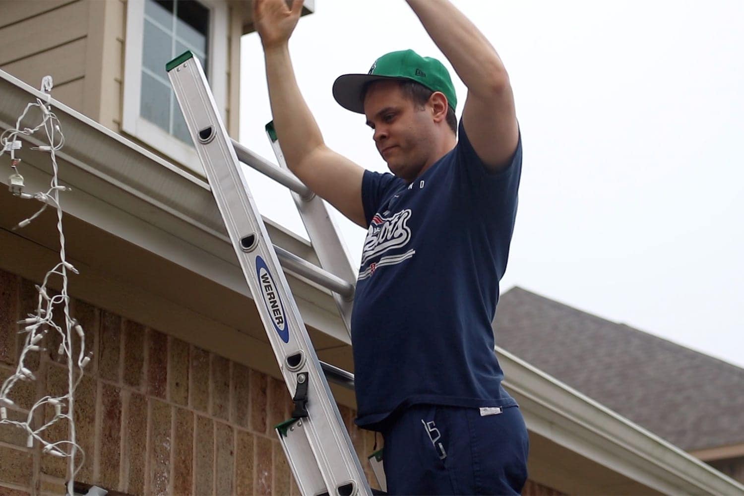 struggling with outdoor Christmas lights on a ladder - holiday bloopers