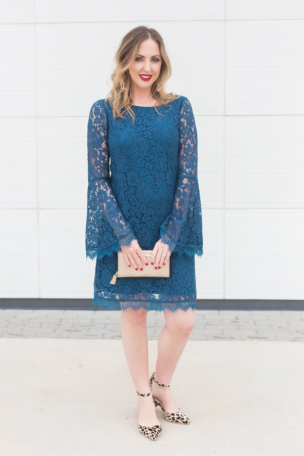 Houston blogger Meg O. on the Go wearing a blue lace bell sleeve dress with leopard print shoes, gold earrings, and a gold clutch